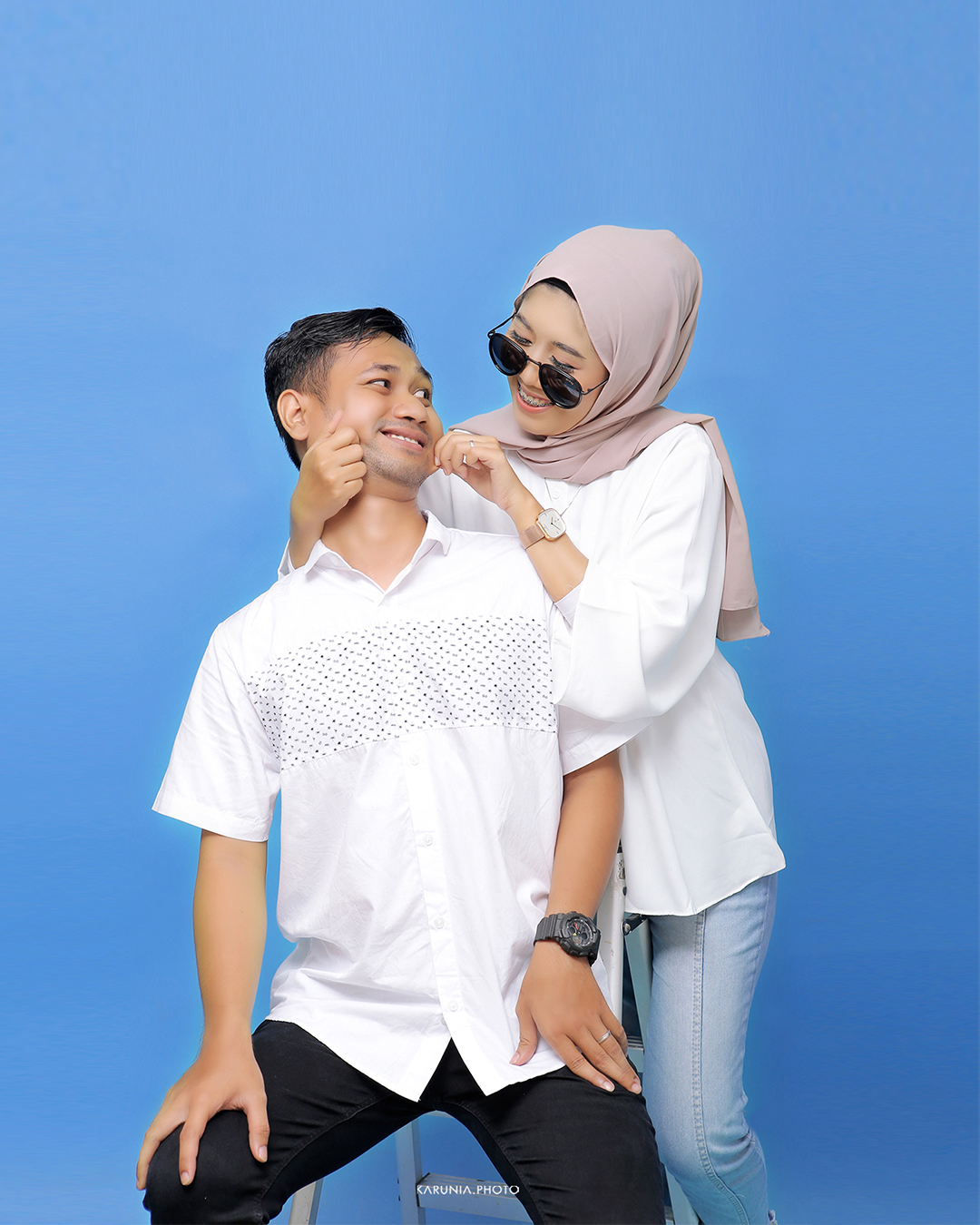 Bride and groom-to-be holding hands and walking along city streets with romantic bokeh lights